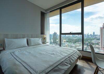 Modern bedroom with a large window offering a city view