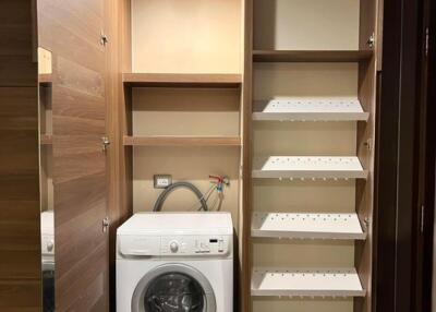 Utility room with washing machine and shelving