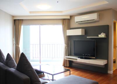 Modern living room with a TV, sofa, and air conditioning unit