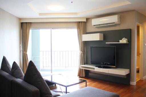 Modern living room with a TV, sofa, and air conditioning unit