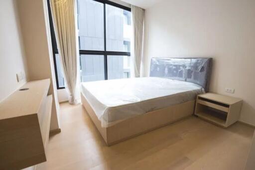 Bedroom with a large window, bed, and nightstand