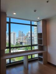 Room with large window overlooking city skyline