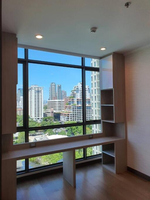 Room with large window overlooking city skyline