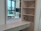 Bedroom with built-in vanity, shelves, large window, city view, and wall-mounted television