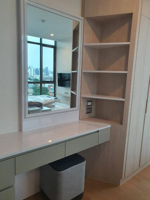 Bedroom with built-in vanity, shelves, large window, city view, and wall-mounted television