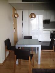 Modern dining area with glass table and four chairs