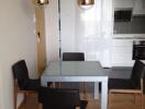 Modern dining area with glass table and four chairs