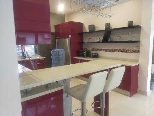 Modern kitchen with red cabinetry and white countertops