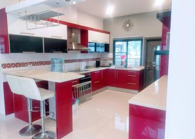 Modern kitchen with red cabinets and breakfast bar