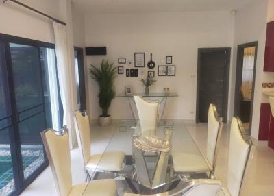 Modern dining room with glass table and white chairs