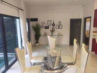 Modern dining room with glass table and white chairs