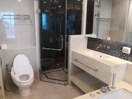 Modern bathroom with glass-enclosed shower, toilet, and sink