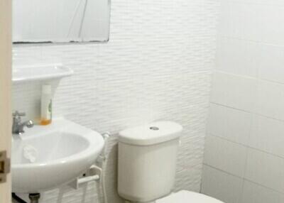 White wall bathroom with sink, mirror, and toilet