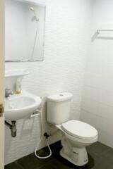 White wall bathroom with sink, mirror, and toilet