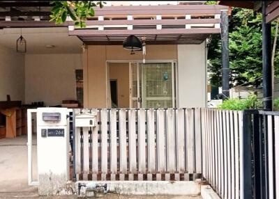 Front view of house showing white fence, mailbox, and garage