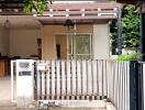 Front view of house showing white fence, mailbox, and garage