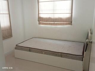 Small bedroom with single bed and two windows with blinds