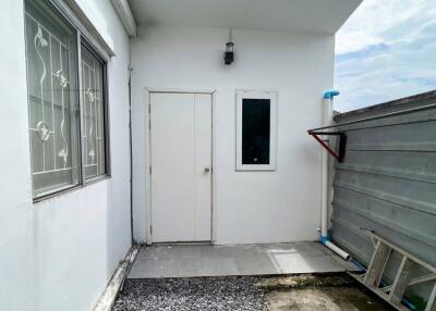 Backyard with white walls and a small paved walkway