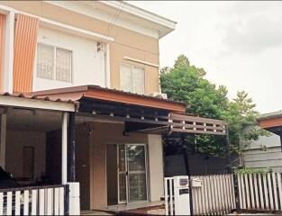 Two-story house with a covered entrance and fenced yard