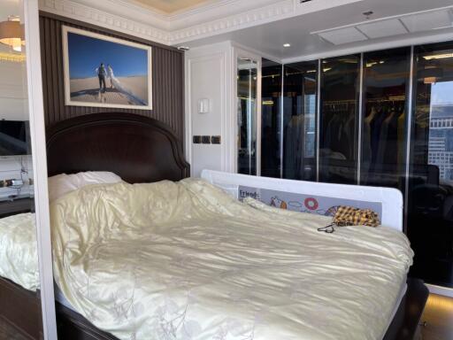 Master bedroom with large bed, wardrobe, and city view