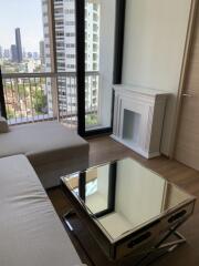 Modern living room with city view, featuring a fireplace and mirrored coffee table