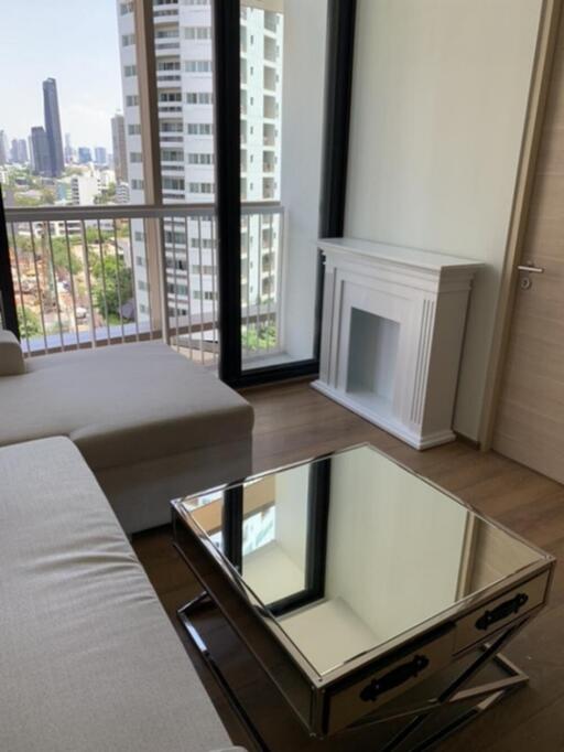 Modern living room with city view, featuring a fireplace and mirrored coffee table