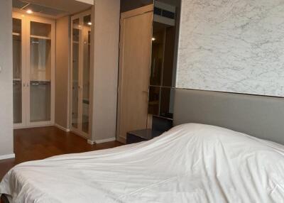 Modern bedroom with white bedding and mirrored closet