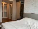 Modern bedroom with white bedding and mirrored closet