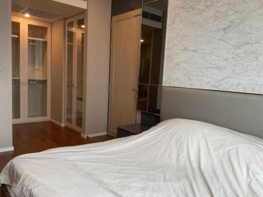 Modern bedroom with white bedding and mirrored closet