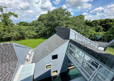 Modern building with unique roofs and lush green surroundings