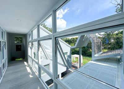 Bright hallway with large windows overlooking greenery