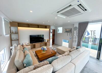 Modern living room with large sofa, coffee table, and entertainment center