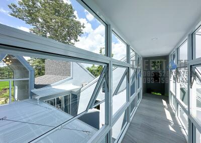 Enclosed walkway with large windows offering exterior views