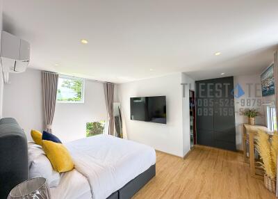 Spacious master bedroom with modern decor and natural light.