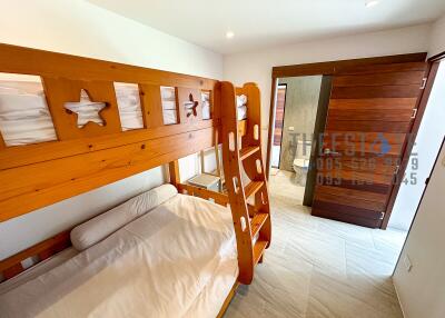 Bunk beds in a small bedroom with a view of the bathroom