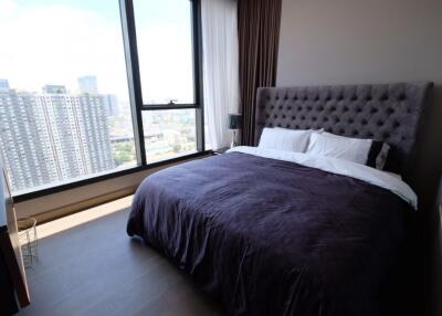 Modern bedroom with large window and city view