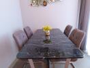 Modern dining room with a dark marble table and stylish chairs