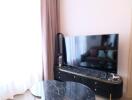 Modern living room with a marble coffee table and large TV