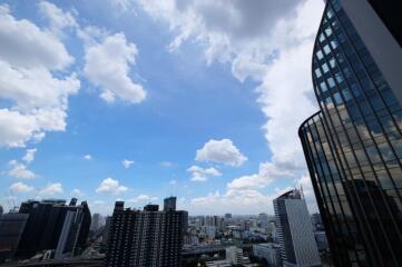 Photo of a cityscape with modern buildings and a blue sky with clouds