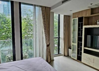 Spacious bedroom with large windows and built-in entertainment unit