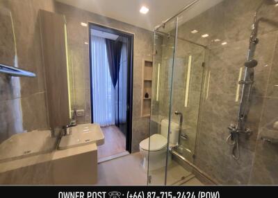 Modern bathroom with glass shower and marble walls