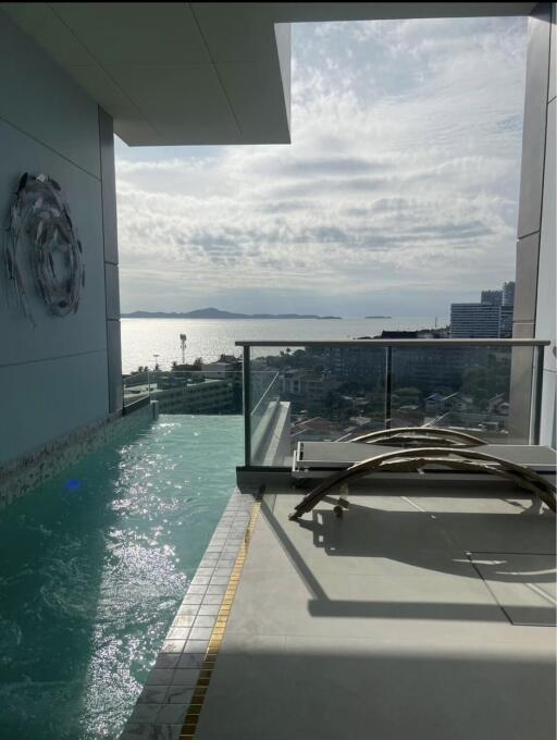 Balcony with a pool and ocean view