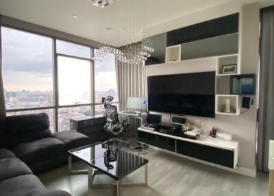 Modern living room with city view, large window, and entertainment setup