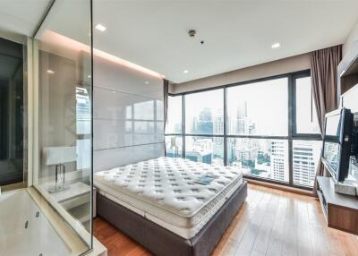 Modern bedroom with large windows and a city view