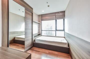 Modern bedroom with wooden floor and large window