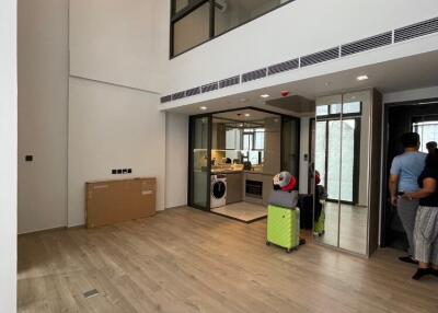 Modern living room with high ceiling and open kitchen