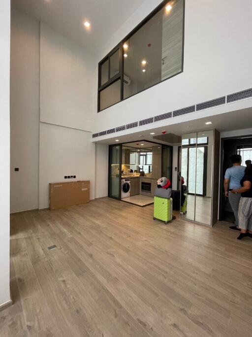 Modern living room with high ceiling and open kitchen