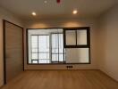 Empty room with wooden floor and large window