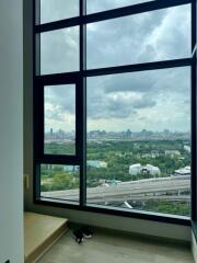 A bedroom with a large window offering a scenic city view