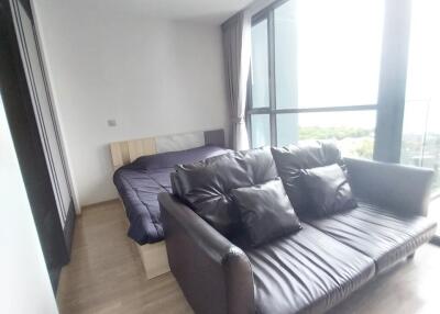 Bedroom with black leather sofa and glass wall